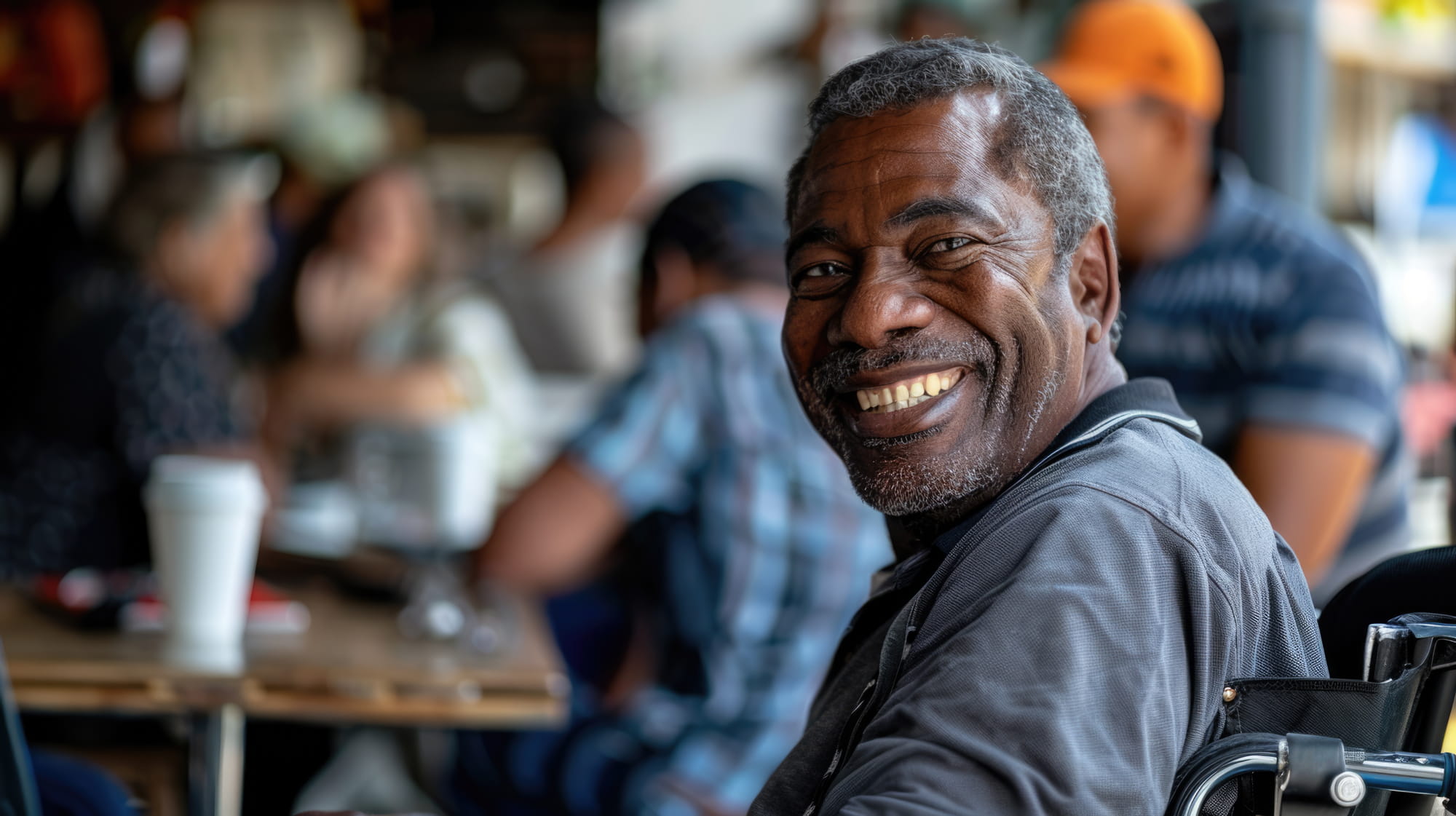 man smiling sitting in a wheelchair