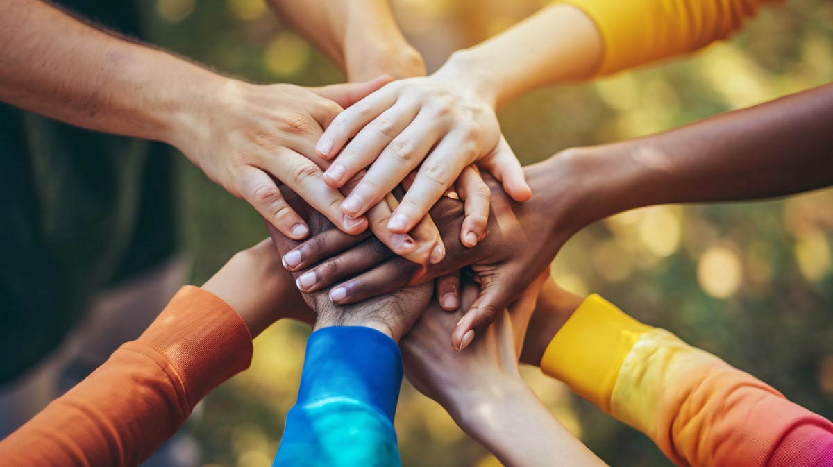 people of all ethnicities with hands stacked